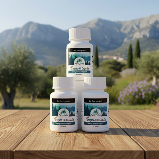 Three bottles of PureVita Oregano Oil Capsules on a wooden table with a mountainous background.