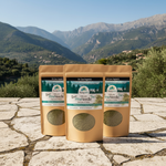 Three packages of Pine Needle Tea on a stone surface with a mountainous landscape in the background